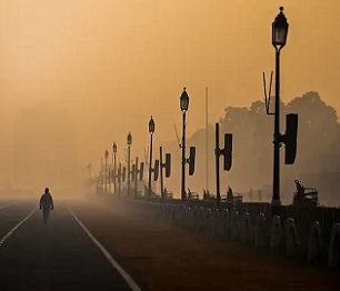 A man walks along Rajpath amid smoggy conditions in New Delhi on January 28, 2021. (Jewel Samad/AFP via Getty Images)