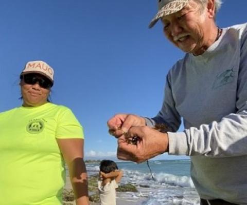 Limu Hui coordinator Wally Ito shows some limu to participants of the organization’s regular limu walks in Hawai‘i, which help locals connect with local seaweed species. Image by Kim Moa/KUA.