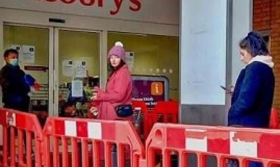 Social distancing while lining up at a supermarket. Credit: Philafrenzy/Wikimedia Commons