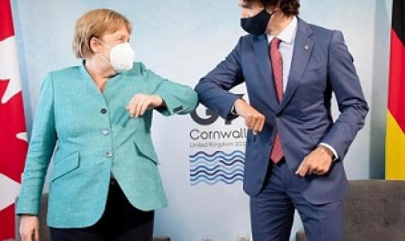 Canadian Prime Minister Justin Trudeau welcomes German Chancellor Angela Merkel at the start of a G7 bilateral meeting. Credit - Associated Press