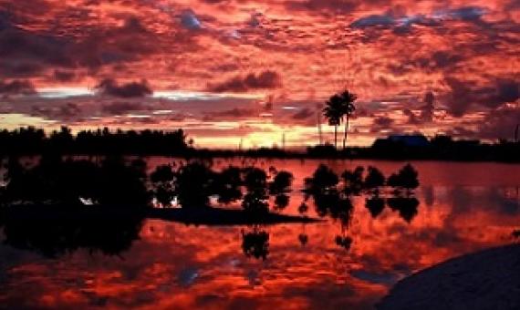 Villagers watch the sunset over a small lagoon near the village of Tangintebu on South Tarawa. The project would involve building the land masses up with sand and gravel. (David Gray/Reuters)