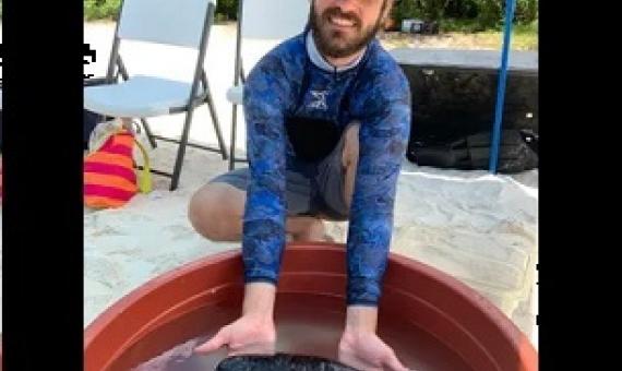 University of Guam Graduate Stiudent holds a sea cucumber at the Guam Wildlife Refuge's critter touch tanks exhibit. Credit - Anne Wen/PDN 